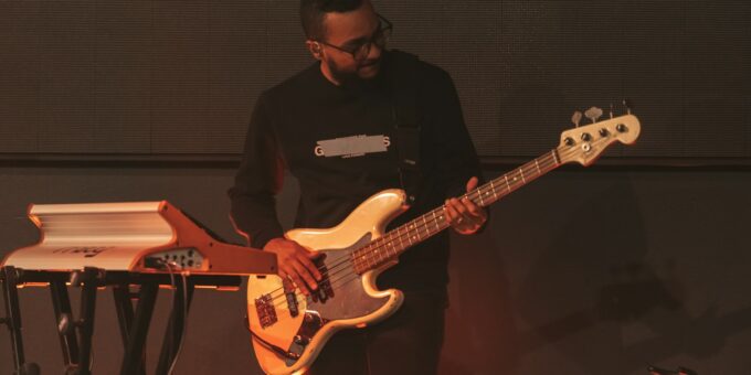 a man standing next to a keyboard and a guitar